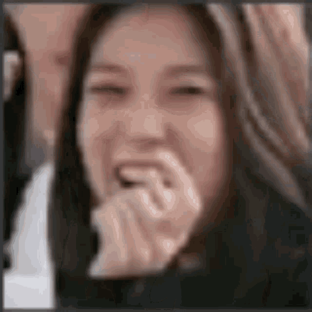a close up of a woman laughing with her mouth open .