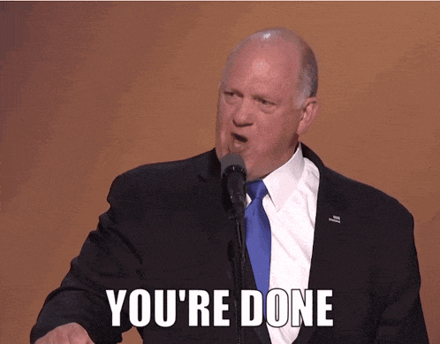 a man in a suit and tie is giving a speech and says you 're done