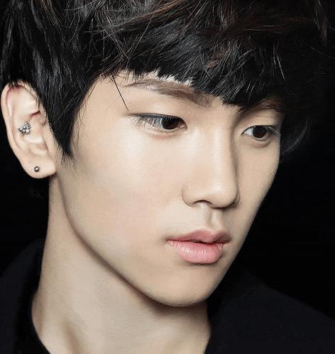 a close up of a person 's face with a piercing in their ear