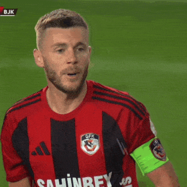 a man wearing a red and black shirt that says bjk