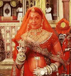 a woman in a red and gold dress holds a teapot