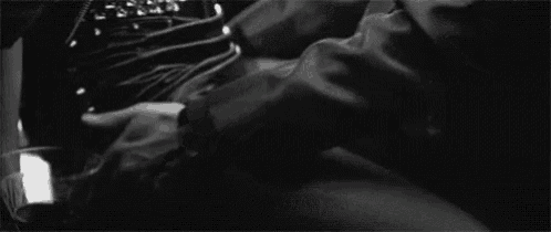a black and white photo of a man touching a woman 's thigh .