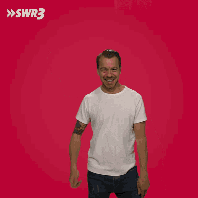 a man with a tattoo on his arm holds his fist up in front of a red background with swr3 written on it