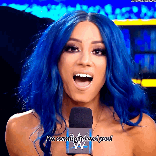 a woman with blue hair is talking into a microphone and saying i 'm coming to end you