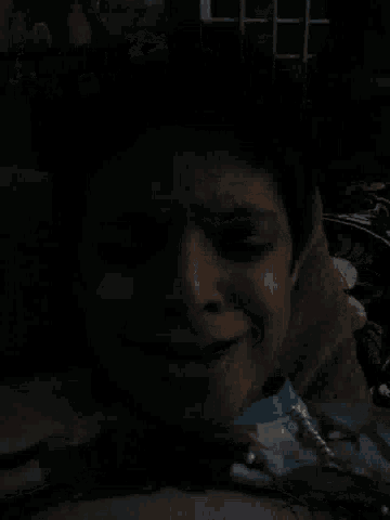 a person with their eyes closed in the dark