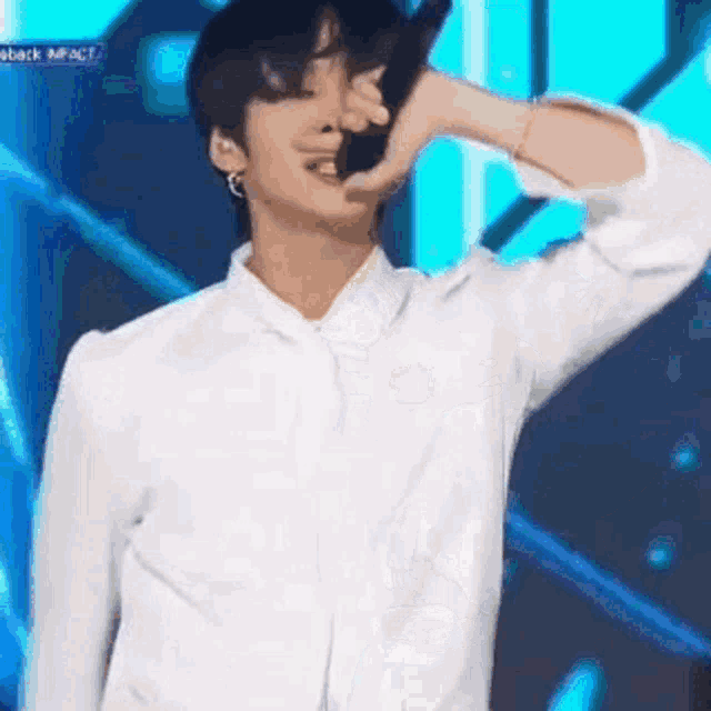 a man in a white shirt is holding a microphone in his hand .