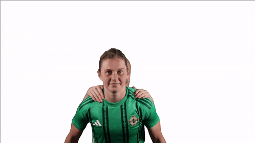 a girl in a green adidas shirt is holding another girl on her shoulders