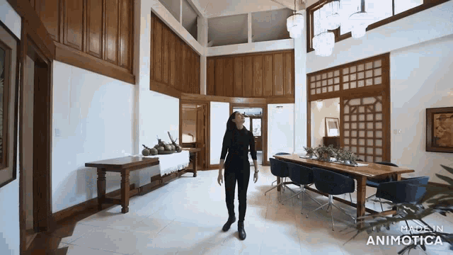 a woman is standing in a large room with the words made in animatica on the bottom left
