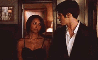 a man in a suit and a woman in a black dress are standing next to each other .