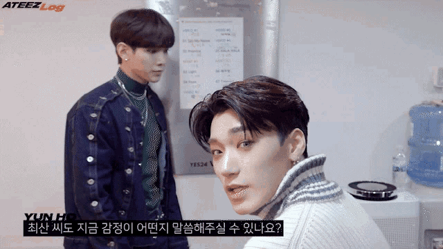 two young men are standing next to each other in front of a sign that says yun hd on it