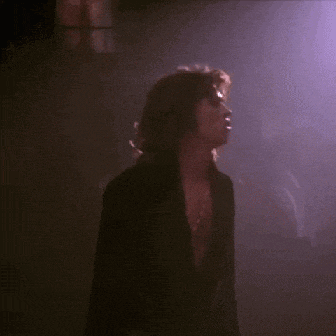 a woman singing into a microphone while a police officer watches