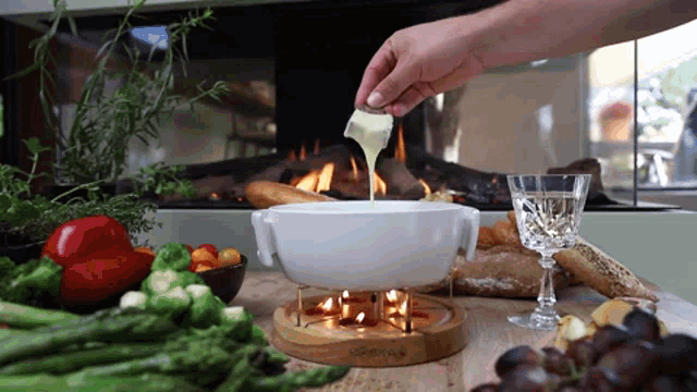 a person is pouring butter into a bowl of fondue
