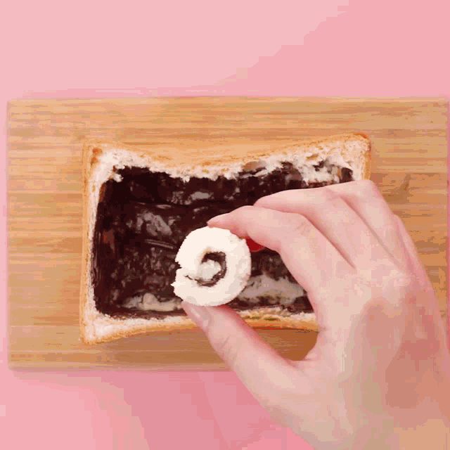 a person is dipping a piece of bread in chocolate