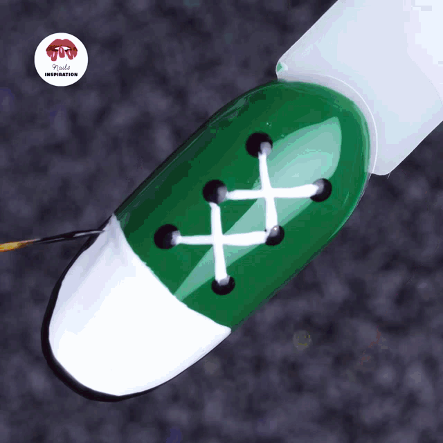 a close up of a green nail with a lace design on it