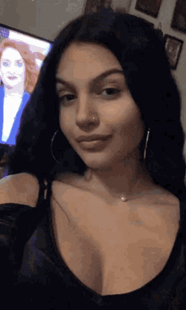 a woman is taking a selfie in front of a tv