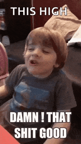a little boy is sitting on a couch with his eyes closed and making a face .