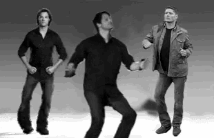 three men are standing next to each other dancing in a black and white photo .
