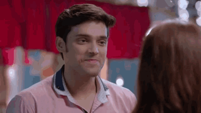 a man and a woman are looking at each other and smiling .