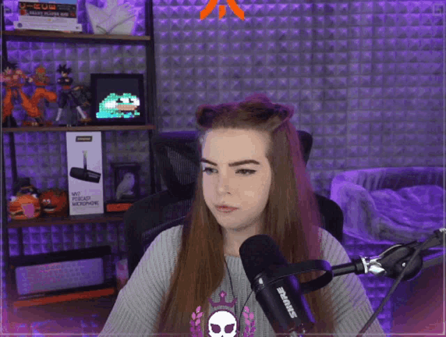 a woman sitting in front of a shure microphone in a room
