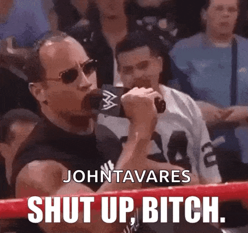 a man in a boxing ring is holding a microphone and saying shut up bitch
