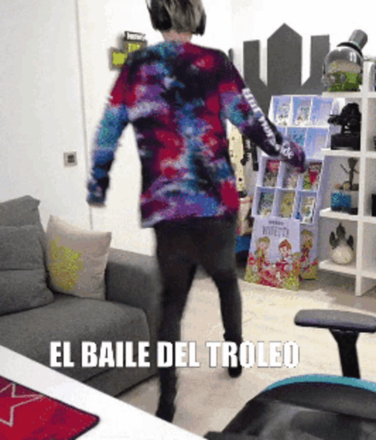 a man in a tie dye shirt is dancing in a living room with the words el baile del trolled on the bottom