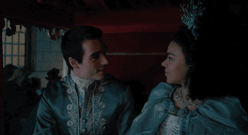 a man and woman are looking at each other in a dark room