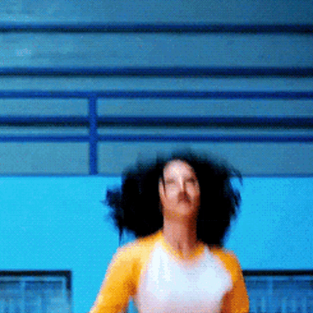 a woman in a yellow shirt and white shirt is dancing