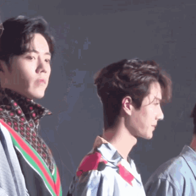 a group of young men are standing next to each other and one of them is wearing a gucci shirt