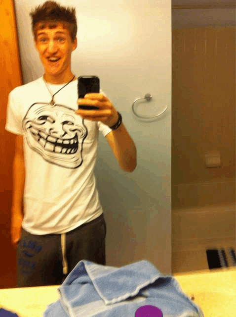 a young man taking a selfie in front of a mirror