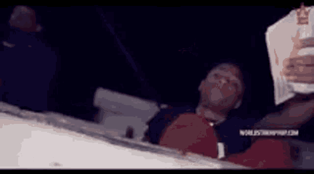 a man is laying on a boat reading a book at night .