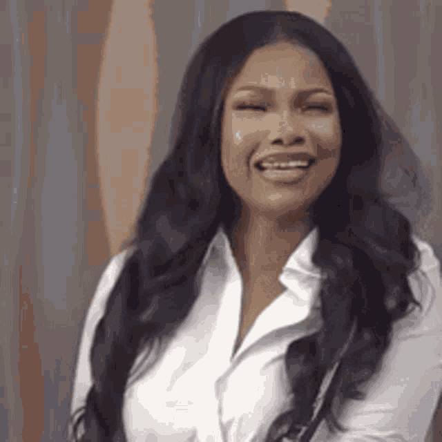 a woman with long black hair and a white shirt is smiling .