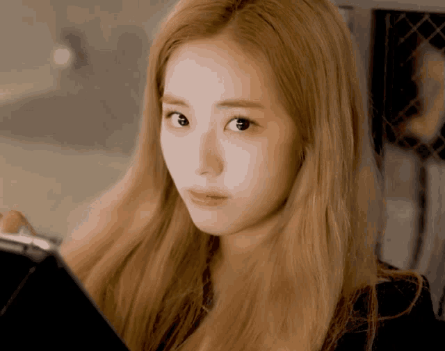 a woman with long blonde hair is looking at something