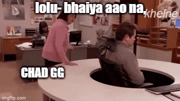 a man is sitting at a desk in an office while a woman stands behind him .