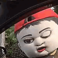 a close up of a mascot wearing a red hat and smoking a cigarette .