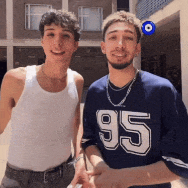 two young men standing next to each other one wearing a shirt that says 95