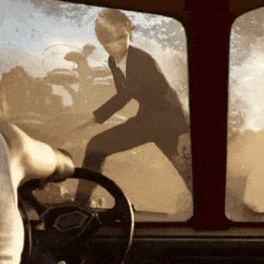 a man in a suit is standing in front of a window