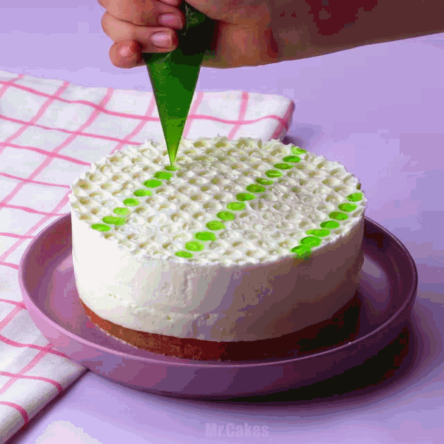 a cake is being decorated with green frosting by mrcakes