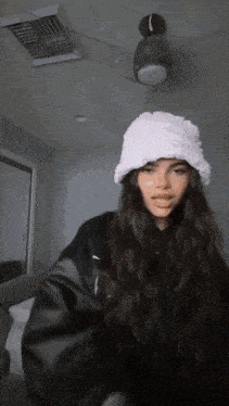 a woman with long hair wearing a white furry hat