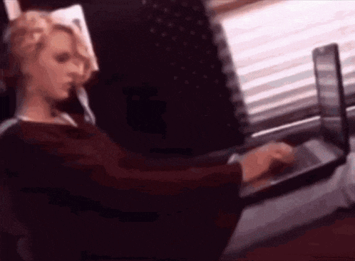 a woman is sitting in front of a laptop computer .