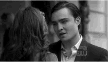a black and white photo of a man and a woman looking at each other