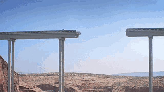 a bridge with a blue sky in the background and a car going over it