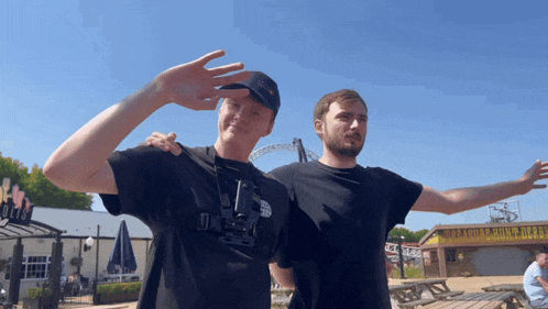 two men standing next to each other with one wearing a t-shirt that says ' the north face '