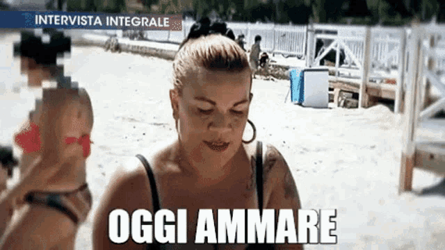 a woman in a bikini is standing on a beach with the words " oggi ammare " on the bottom