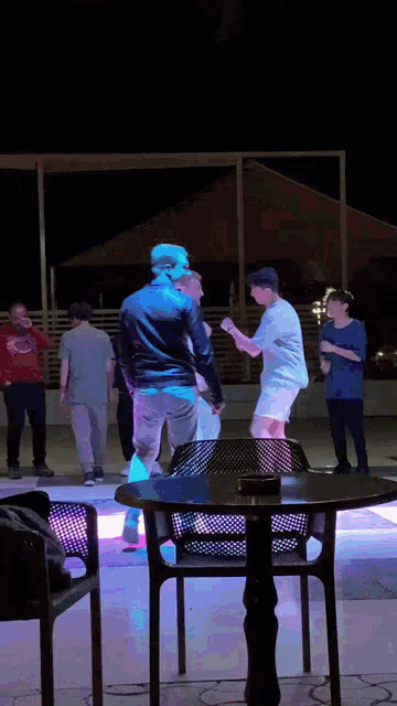 a group of people are dancing on a dance floor with a table in the foreground