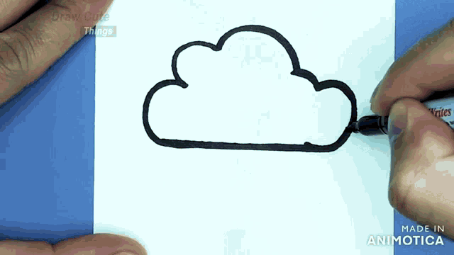 a person is drawing a cloud on a piece of paper with a marker