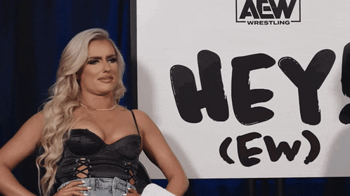 a woman is standing in front of a sign that says hey