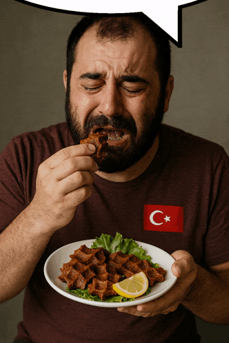 a man eating a plate of food with a turkey flag on his t-shirt