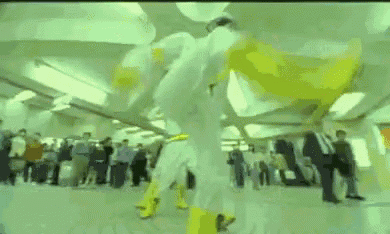 a man in a white suit and yellow boots is holding another man in a yellow cape .