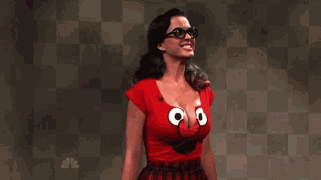 a woman wearing glasses and a red shirt with sesame street characters on it