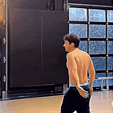 a shirtless man wearing a pair of abercrombie and fitch underwear stands in a room